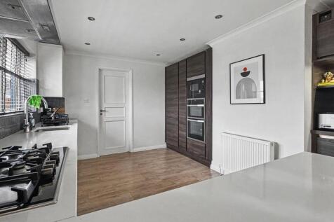 Bright modern kitchen with sleek white countert...