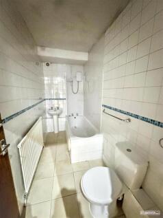 Tiled bathroom with full-size tub and shower...