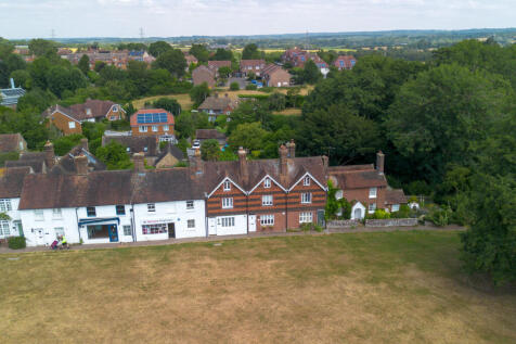 Aerial view of the village green, house and surrounding countryside around the village