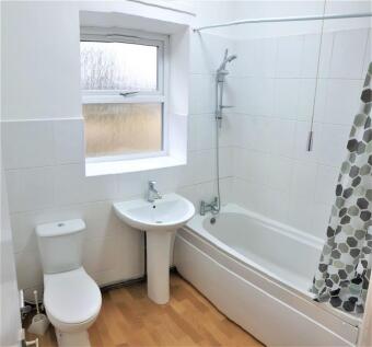 Bright bathroom with a full bathtub and window...