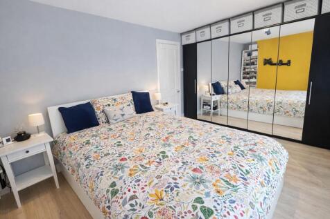 Bright, modern master bedroom with a large doub...