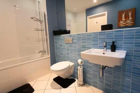 Modern bathroom with blue tiled half-wall, wall...