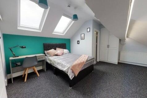 Bright attic bedroom with study desk and skylig...