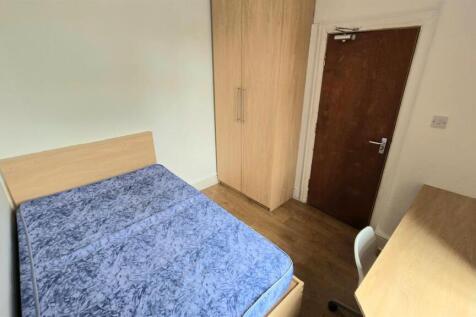 Bright, simply furnished bedroom with a comfort...