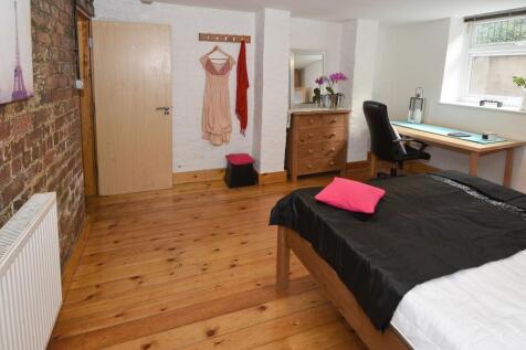 Bright, stylish bedroom with polished wooden fl...