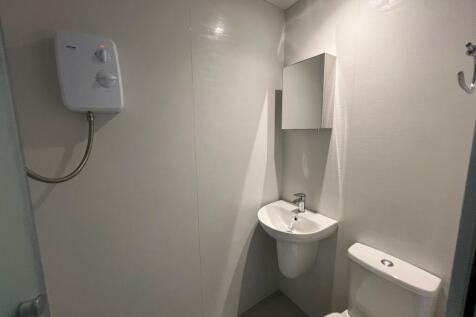 Compact modern bathroom with a wall-mounted bas...