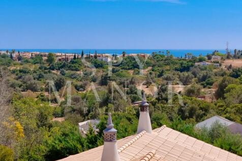 Panoramic views from the rooftop terrace of an Algarvian Quinta in Lagoa. Breathtaking countryside and distant ocean views under a clear blue sky.