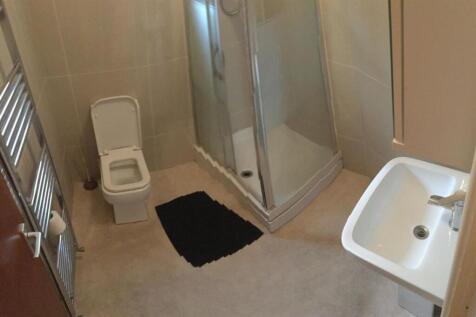 Modern bathroom with walk-in shower and towel r...