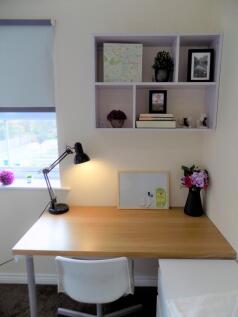 Bright, tidy study nook with a large wooden des...