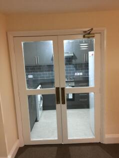 Modern galley-style kitchen viewed through glaz...