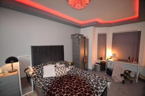 Well-styled bedroom with a large upholstered he...