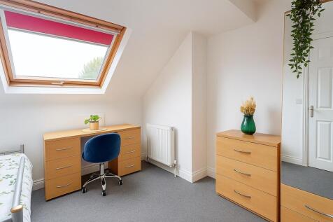 Bright, neatly furnished single bedroom with a ...