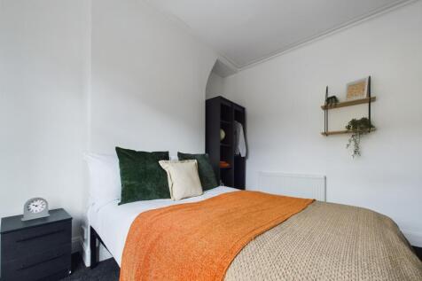 A bright and inviting double bedroom with styli...