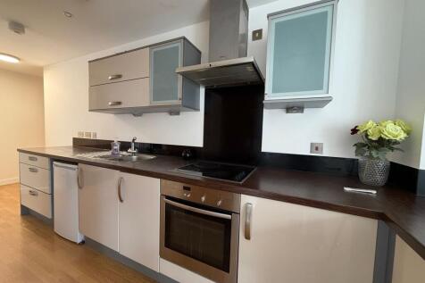 Bright modern kitchen with dark wood countertop...