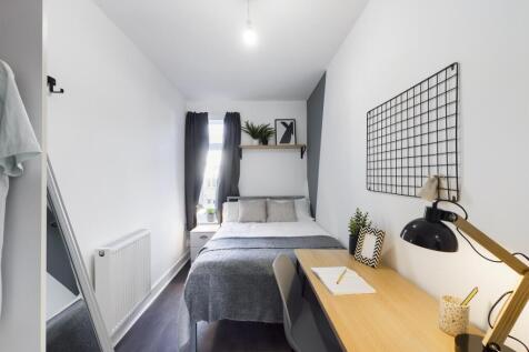 A bright and stylish double bedroom featuring a...