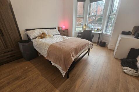 A spacious and well-lit master bedroom featurin...