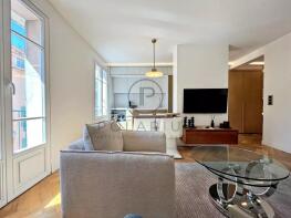 Bright, modern living space with a cozy sofa, glas