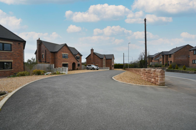 Golden gravel driveway to front and side