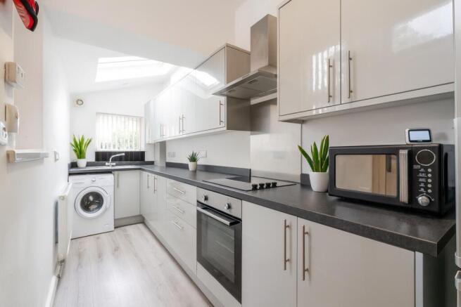 Modern, bright kitchen featuring sleek white ca...