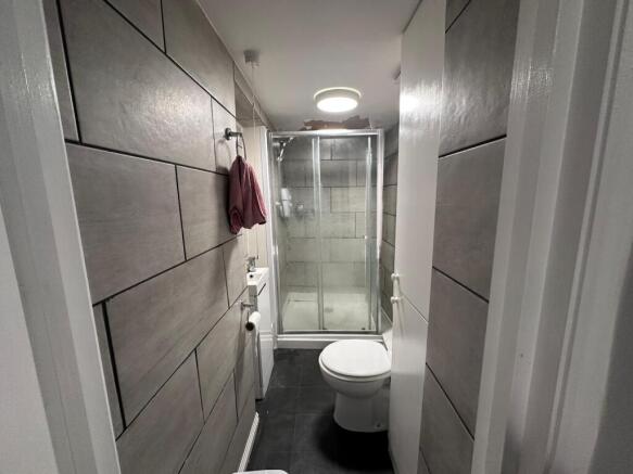 Modern tiled bathroom with a glass-enclosed sho...