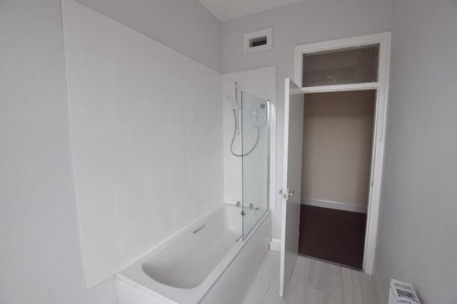 Bright, modern bathroom with a bath and overhea...