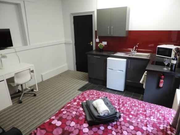 Modern studio with integrated kitchen and desk...