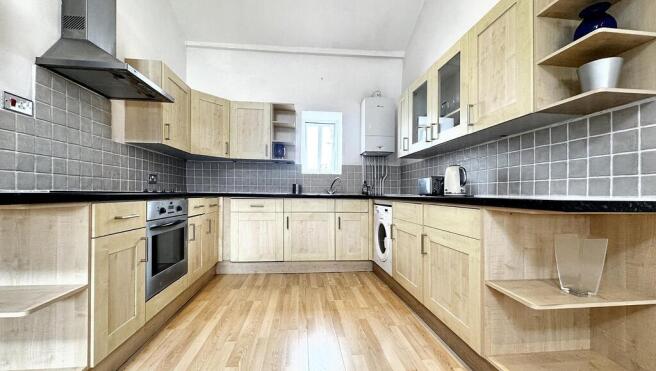Spacious kitchen with modern wood-style cabinet...