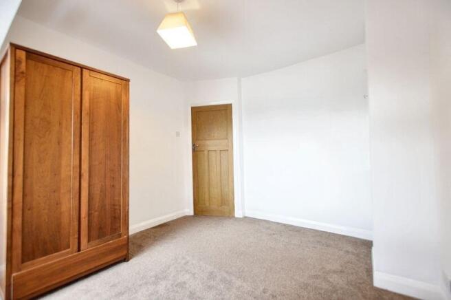 A clean and bright single bedroom featuring a w...