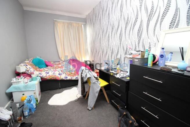 A modestly sized single bedroom featuring a pat...