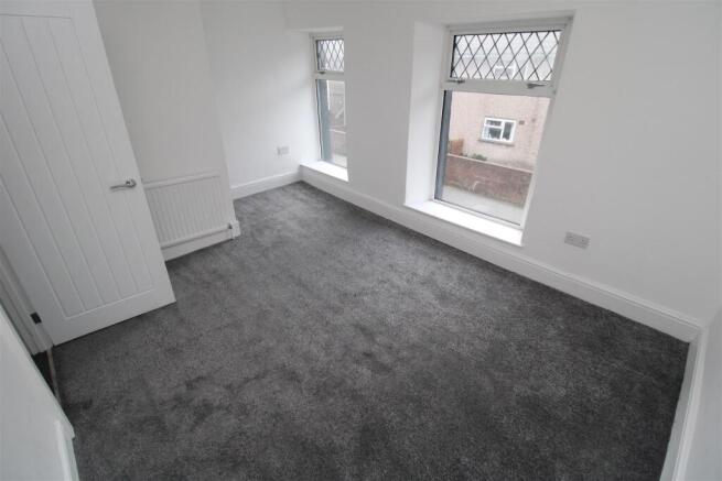 Bright bedroom with fresh carpet and large wind...