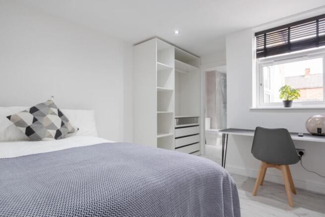 A bright and inviting double bedroom with moder...