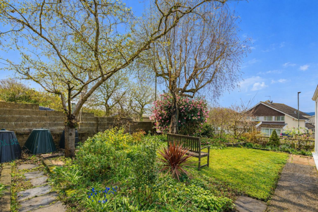 Garden path with blooming trees and bench.png