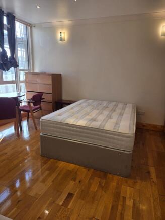 Bright double bedroom with polished wood floors...