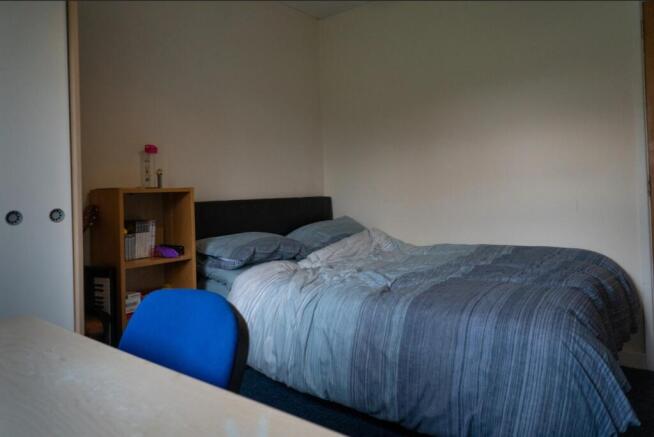A cozy double bedroom featuring a neatly made b...