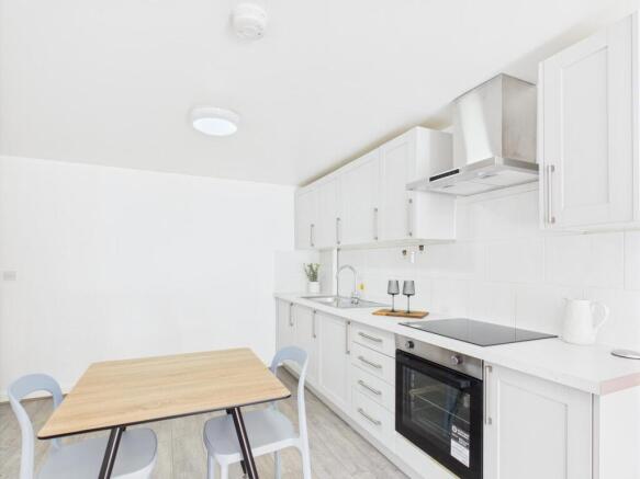 Bright, modern kitchenette with white cabinetry...
