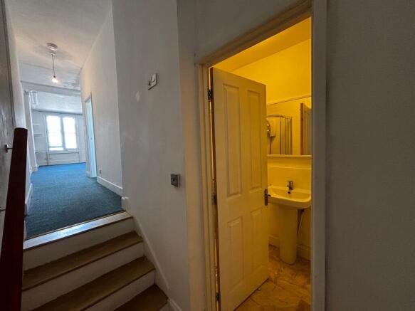 Bright hallway leads to a clean modern bathroom...