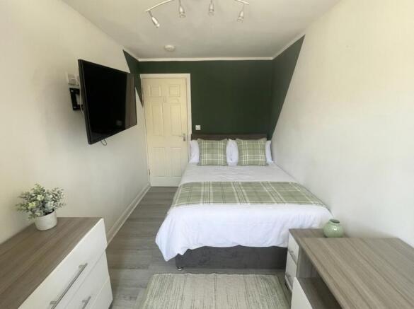 Modern double bedroom with wall-mounted TV...