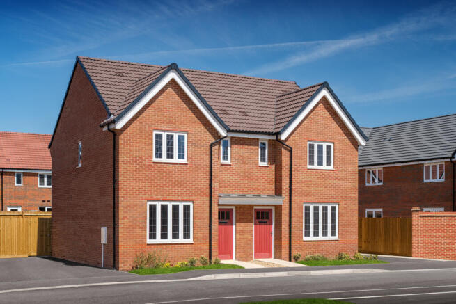 A modern brick semi-detached house with red doors stands in the foreground