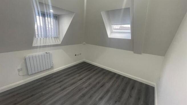 Bright attic bedroom with angled skylow windows...