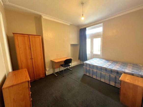 Bright, simply furnished single bedroom with a ...