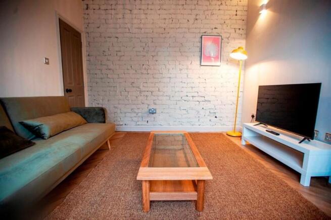 Stylish living room with exposed brick accent w...