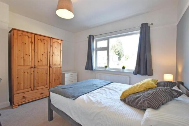 Bright bedroom with ample storage and natural l...