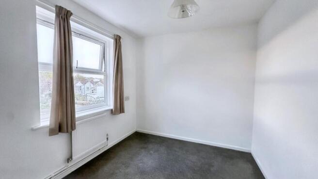 Bright bedroom with large window and carpet...