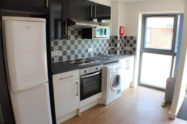 Modern kitchen with sleek units and bright wind...