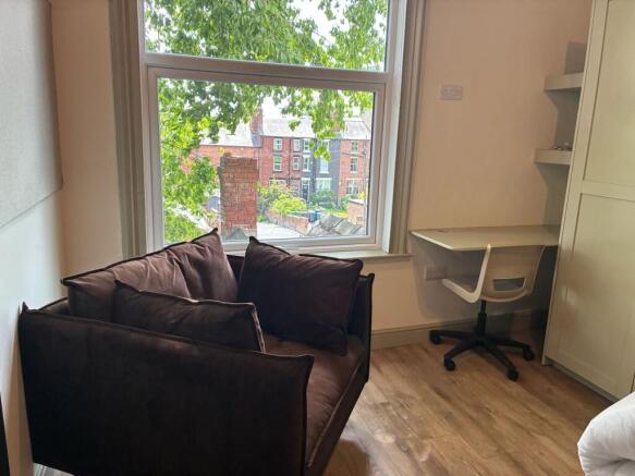 Bright bedroom with large window and study desk...