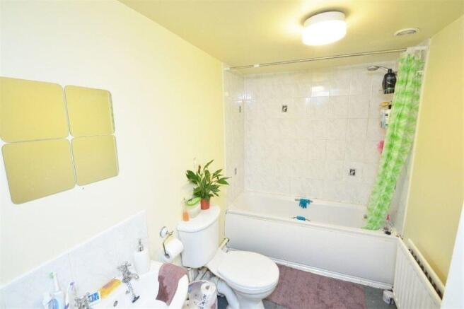 Bright, clean bathroom with a bathtub and showe...