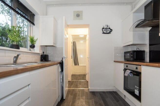 Bright modern galley kitchen with wood-effect w...