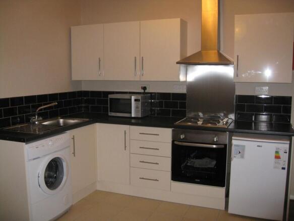 Bright modern kitchen with black tiled splashba...