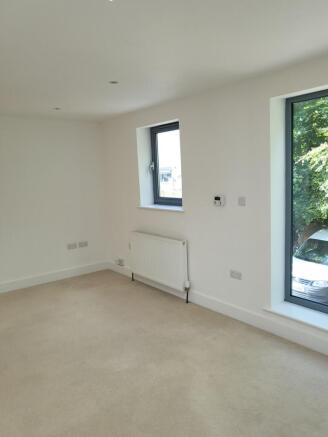 Bright, neutral bedroom with large windows brin...