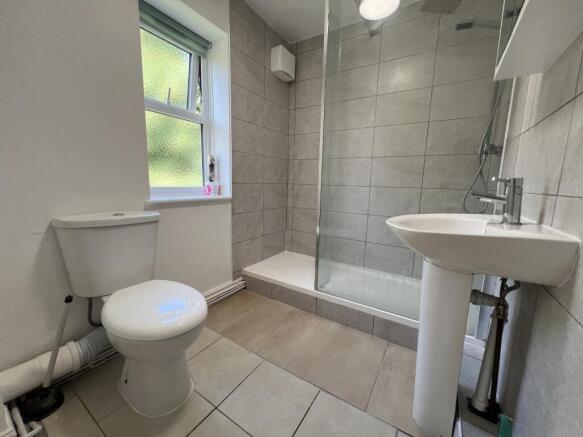 Light-filled modern bathroom with tiled walk-in...